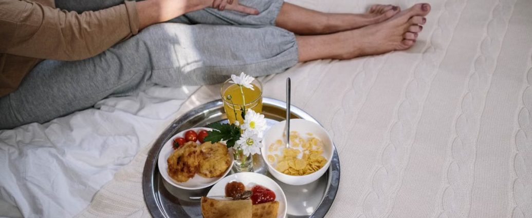 Cozy morning breakfast in bed featuring pancakes, fruit, and flowers. Perfect start to the day.