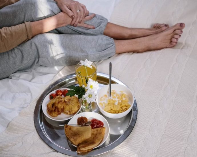 Cozy morning breakfast in bed featuring pancakes, fruit, and flowers. Perfect start to the day.